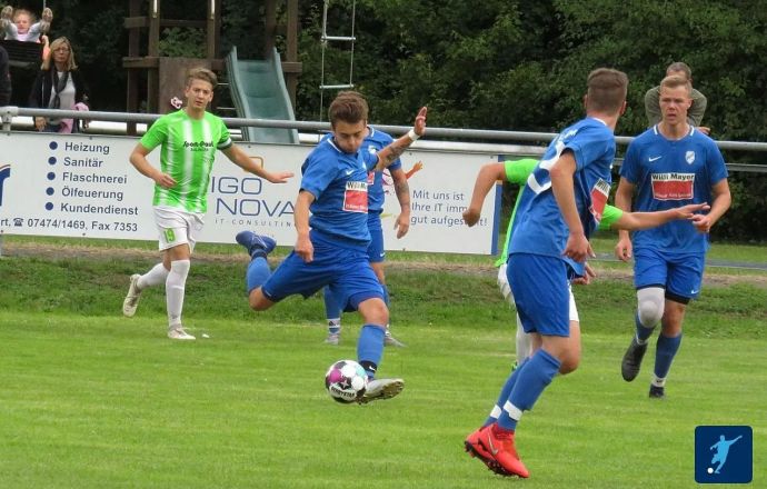 ugend-Fußballspiel in Bisingen mit Spielern in blauen und grünen Trikots, symbolisiert Teamgeist und Dynamik.