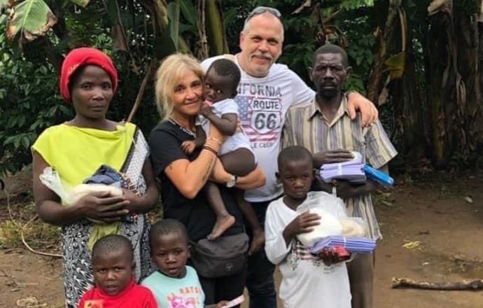 Gruppe mit Erwachsenen und Kindern vor Bananenstauden, symbolisiert Gemeinschaft und Unterstützung von Masaka Kids Afrikana e.V.